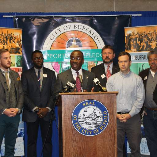 Buffalo Mayor Byron Brown, flanked by the staff and Advisory Board of Open Buffalo, discusses the significance of the City of Buffalo Opportunity Pledge.